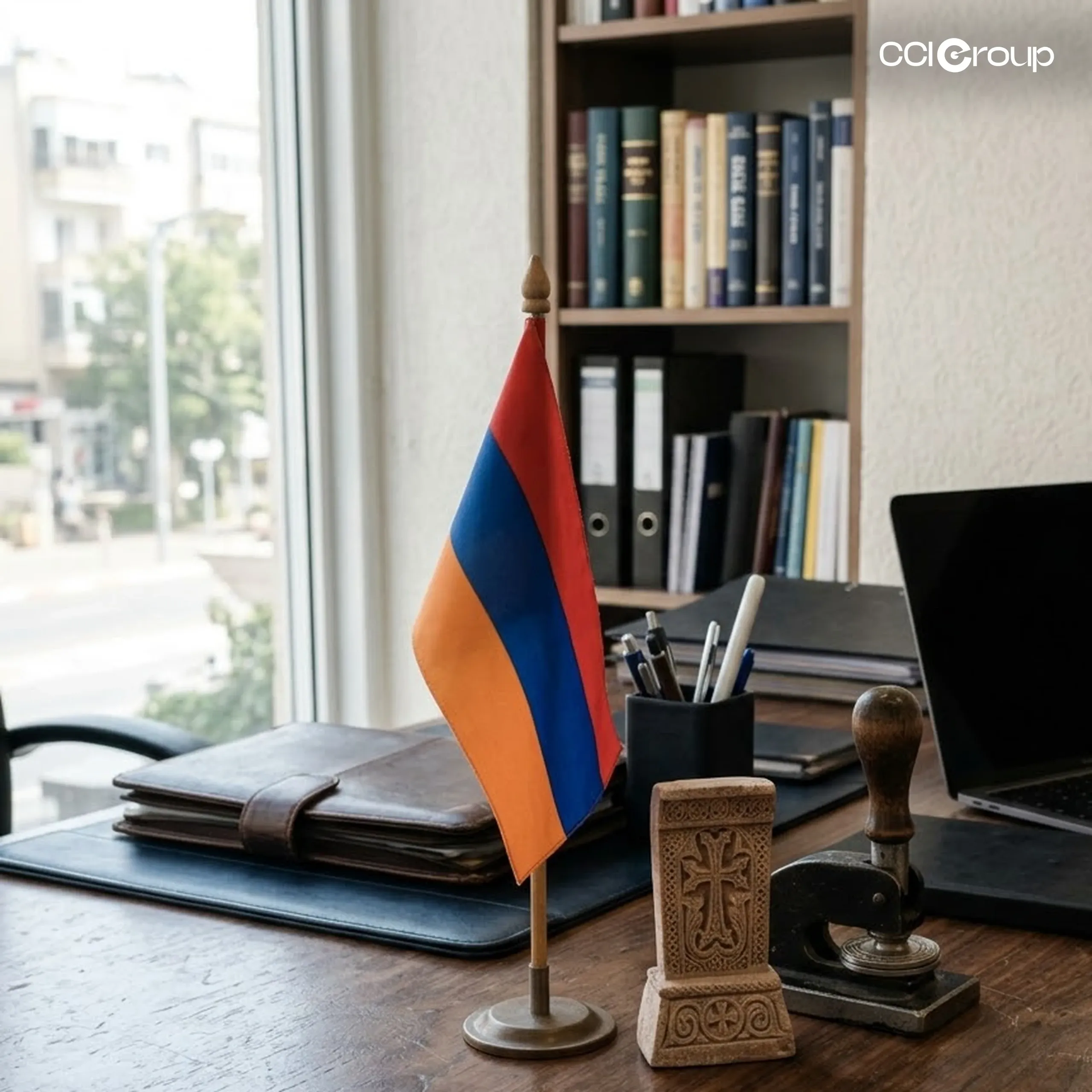 Armenian desk flag beside a carved cross-stone ornament and vintage embosser stamp on a lawyer's desk, representing Armenian notarization services from CCI Group.